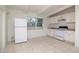 Bright kitchen with white appliances and cabinets, tile floors and natural light at 2004 Windsor Way, Tampa, FL 33619