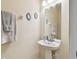 Bathroom featuring a pedestal sink with decorative mirrors and modern fixtures at 2347 Willimette Dr, Wesley Chapel, FL 33543