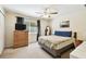 Comfortable bedroom featuring a ceiling fan, natural light, and neutral carpeting at 2347 Willimette Dr, Wesley Chapel, FL 33543