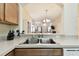 Kitchen stainless steel sink and view into the living room with neutral walls at 2347 Willimette Dr, Wesley Chapel, FL 33543