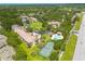 An aerial showing the community's proximity to lush surroundings, a community pool and tennis courts at 3044 Red Oak Ct # 204, Palm Harbor, FL 34684