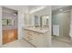 Bathroom with double sinks, tile flooring, and shower, with an open view to the bedroom at 3044 Red Oak Ct # 204, Palm Harbor, FL 34684
