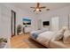 This spacious main bedroom features beautiful wood floors, a ceiling fan, and a slider to the screened porch at 3044 Red Oak Ct # 204, Palm Harbor, FL 34684