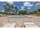 Outdoor pool area featuring lots of lounge chairs and shady trees at 3044 Red Oak Ct # 204, Palm Harbor, FL 34684