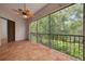 The spacious tiled floor, ceiling fan, and screened enclosure offer a relaxing space to enjoy the surrounding green views at 3044 Red Oak Ct # 204, Palm Harbor, FL 34684