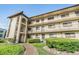 Exterior angle view of the condo showing the balconies, walkways, landscaping, and the entrance at 3055 Casa Del Sol Cir # 202, Clearwater, FL 33761
