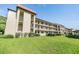 Low angle shot of a condominium complex with green grass and balconies at 3055 Casa Del Sol Cir # 202, Clearwater, FL 33761