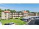 Exterior view of the three-story condo building with balconies and covered parking spaces at 3055 Casa Del Sol Cir # 202, Clearwater, FL 33761