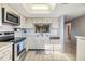Modern kitchen featuring white cabinets and tiled floors at 3055 Casa Del Sol Cir # 202, Clearwater, FL 33761