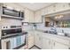 Bright kitchen with white cabinets, stainless steel appliances, and an open design at 3055 Casa Del Sol Cir # 202, Clearwater, FL 33761