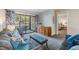 Well-lit living area with sliding glass doors to the balcony and a view into the bedroom at 3055 Casa Del Sol Cir # 202, Clearwater, FL 33761