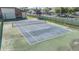 Outdoor community tennis court bordered by a green buffer and fencing at 3055 Casa Del Sol Cir # 202, Clearwater, FL 33761