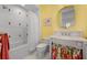 Cozy bathroom featuring a shower-tub combo, vanity with floral accents, and warm lighting for a relaxing experience at 3125 Christophers Watch Ln, Ruskin, FL 33570