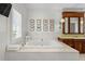 Bright bathroom featuring a soaking tub, framed botanicals, and a custom vanity with ample storage at 3125 Christophers Watch Ln, Ruskin, FL 33570