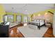 Spacious main bedroom with yellow walls, stone accent wall, and beautiful hardwood flooring at 3125 Christophers Watch Ln, Ruskin, FL 33570