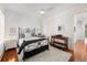 Comfortable bedroom featuring hardwood floors, shutters, and a decorative iron bed frame at 3125 Christophers Watch Ln, Ruskin, FL 33570