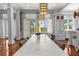 Bright dining area featuring a long white table, statement lighting, and natural light from outdoor access at 3125 Christophers Watch Ln, Ruskin, FL 33570