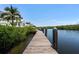 Wooden dock extending into tranquil water with lush greenery on the shoreline at 3125 Christophers Watch Ln, Ruskin, FL 33570