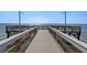 Pier with wooden railings extends into the bay with serene water views and distant skyline at 3125 Christophers Watch Ln, Ruskin, FL 33570