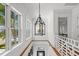 Bright hallway with white wainscoting, wood accents, and modern wrought iron chandelier at 3125 Christophers Watch Ln, Ruskin, FL 33570