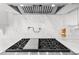 Gourmet kitchen area with stainless steel vent hood and cooktop, and marble backsplash, ready for cooking at 3125 Christophers Watch Ln, Ruskin, FL 33570