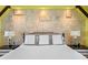 Close-up of main bedroom with stone accent wall and lamps on either side of the bed at 3125 Christophers Watch Ln, Ruskin, FL 33570