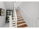 Elegant staircase featuring light wood treads and a white lattice railing, adding architectural detail at 3125 Christophers Watch Ln, Ruskin, FL 33570