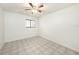 Bright bedroom featuring tile floors, ceiling fan, and a dark-framed window at 31645 Bugle Ln, Wesley Chapel, FL 33543