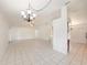 Spacious living area with tile flooring, featuring an open layout and stylish chandelier at 31645 Bugle Ln, Wesley Chapel, FL 33543
