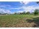 Expansive grassy lot under a bright blue sky with scattered clouds is ready for building your dream home at 31645 Bugle Ln, Wesley Chapel, FL 33543