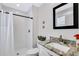 Bathroom featuring white shower tiles, white walls, and a stone countertop sink at 340 6Th E St, Bradenton, FL 34208
