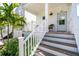 Inviting front porch with stairs, a seating area, and lush landscaping enhances this home's curb appeal at 340 6Th E St, Bradenton, FL 34208