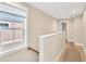 Sunlit hallway with hardwood floors, white railings, and views to the outside at 340 6Th E St, Bradenton, FL 34208