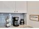 Coffee bar area with modern coffee maker, gray subway tile backsplash, and white cabinets enhances the kitchen at 340 6Th E St, Bradenton, FL 34208