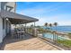 A beautiful balcony with outdoor seating overlooks a pool, bay, and palm trees at 340 Sapphire Lake Dr # 202, Bradenton, FL 34209
