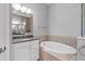 Bathroom boasts a soaking tub with tile surround, granite counters, and a walk-in shower at 340 Sapphire Lake Dr # 202, Bradenton, FL 34209