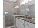 A bathroom featuring tile, a glass enclosed shower, granite countertop, and white cabinets at 340 Sapphire Lake Dr # 202, Bradenton, FL 34209