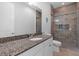 Well-lit bathroom features granite countertops, white cabinets and a tile shower with glass door at 340 Sapphire Lake Dr # 202, Bradenton, FL 34209