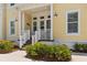 Inviting front porch with seating area and manicured landscaping enhances this yellow townhome at 340 Sapphire Lake Dr # 202, Bradenton, FL 34209
