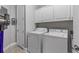 Efficient laundry room with washer, dryer, and overhead storage at 340 Sapphire Lake Dr # 202, Bradenton, FL 34209