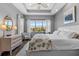 This main bedroom features tray ceilings, wood-look floors, and a large window overlooking the neighborhood at 340 Sapphire Lake Dr # 202, Bradenton, FL 34209