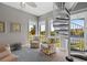 Bright sunroom with spiral staircase, armchairs, and views of lush landscaping and water at 340 Sapphire Lake Dr # 202, Bradenton, FL 34209