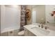 Stylish bathroom featuring a white vanity with quartz countertops, a bathtub with a shower, and a decorative wall shelf at 3411 Lumber Falls Dr, Plant City, FL 33565