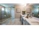 Elegant bathroom featuring a large vanity with double sinks, a spacious walk-in shower, and neutral tile flooring at 3411 Lumber Falls Dr, Plant City, FL 33565