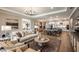 Bright, open floor plan featuring a living area, dining space, and kitchen, all with hardwood floors and modern decor at 3411 Lumber Falls Dr, Plant City, FL 33565