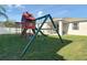 Backyard featuring a playhouse, swing set and green lawn at 3512 Gerrads Cross Ct, Land O Lakes, FL 34638
