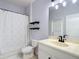 Well-lit bathroom with vanity, toilet, decorative shelves, and tiled shower/tub combo at 3512 Gerrads Cross Ct, Land O Lakes, FL 34638