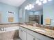 Bathroom with dual vanity sinks, soaking tub, walk-in shower and tiled walls at 3512 Gerrads Cross Ct, Land O Lakes, FL 34638