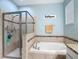 Bathroom with a walk-in shower, tub, and tiled walls at 3512 Gerrads Cross Ct, Land O Lakes, FL 34638