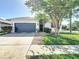 Charming single-story home with a well-manicured lawn and a two-car garage at 3512 Gerrads Cross Ct, Land O Lakes, FL 34638